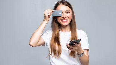 cheerful excited young woman with mobile phone and credit card