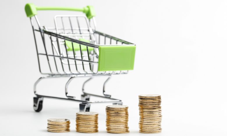 coins pile and shopping cart on a white background