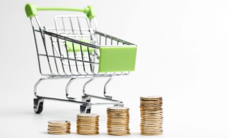 coins pile and shopping cart on a white background
