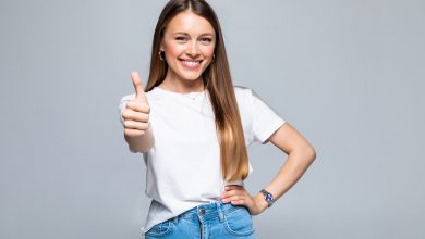 happy female college student showing thumbs up isolated