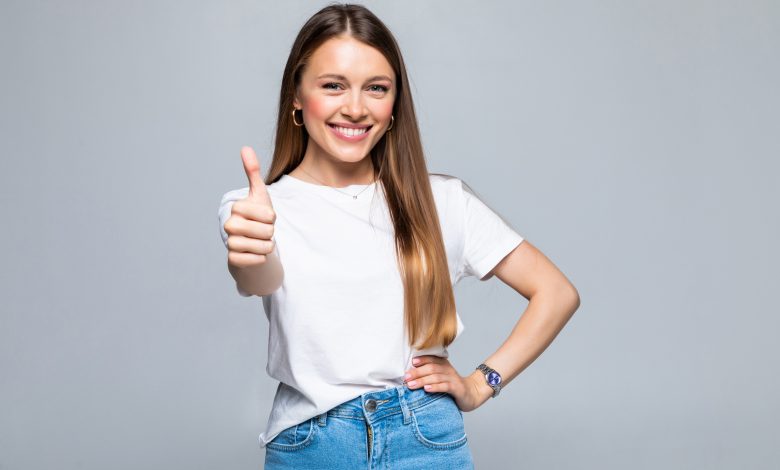 happy female college student showing thumbs up isolated