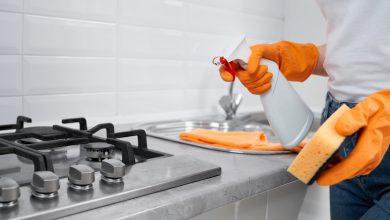 woman holding rag and detergent for cleaning cooker