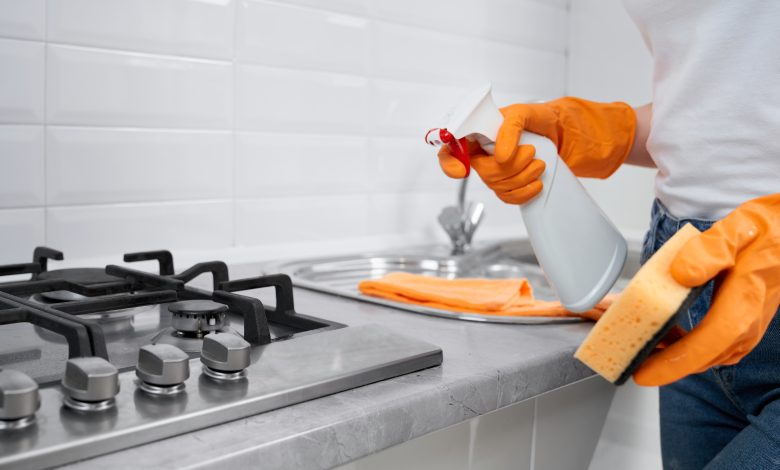 woman holding rag and detergent for cleaning cooker