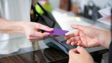 customer giving credit card to cashier over desk with pos terminal for payment cropped shot closeup of hands shopping concept