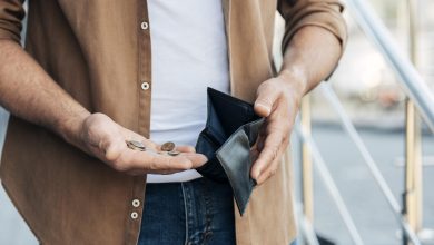 close up hands holding wallet and coins