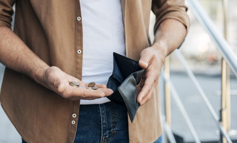 close up hands holding wallet and coins